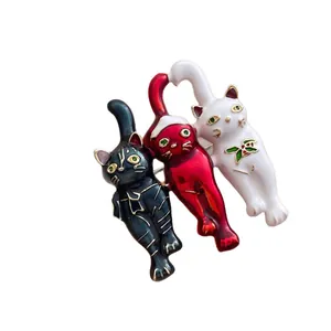 Vintage cat brooches with enamel finish and festive Christmas hats on white background