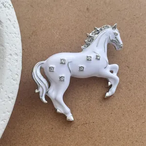 Broche exquise en forme de cheval au galop avec émail blanc et accents de cristaux