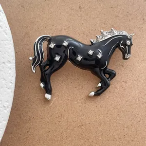 Détail d'une élégante broche cheval en émail noir avec crinière argentée et cristaux