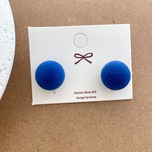 Close-up of royal blue flocked ball earrings with 925 silver studs on display card