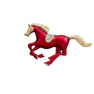 Running horse brooch in red enamel and gold finish with sparkling diamond accents