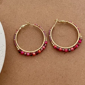 Handcrafted gold wire hoop earrings featuring vibrant gradient faceted beads and warm vintage aesthetics