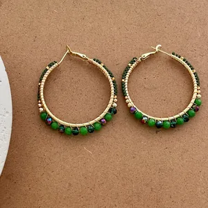 Exaggerated vintage gold hoops with green seed beads and colorful hanging charms