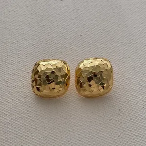 Detailed macro view of 18k gold plated square earrings with faceted crushed ice texture