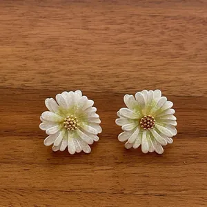 Detailansicht der Gänseblümchen-Ohrstecker mit weiß-grünen Blüten und goldenem Kern
