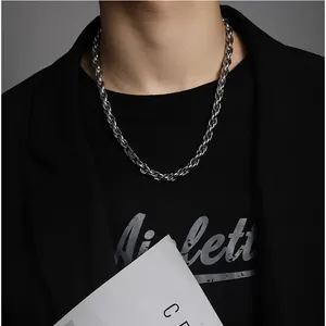 Detail of silver twisted rope chain necklace on model with street style aesthetic