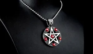 Detailansicht des Vintage-Pentagramm-Anhängers mit roten Kristallen auf schwarzem Ständer
