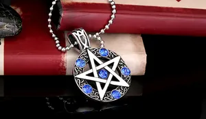 Detail eines Vintage-Stahl-Pentagramm-Anhängers mit blauen Steinen auf schwarzem Reflex