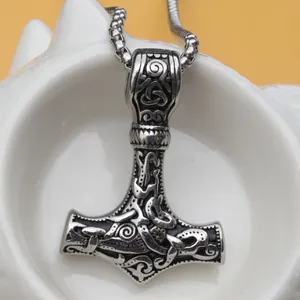 Détail macro du pendentif marteau de Thor Mjolnir en acier avec nœuds celtiques