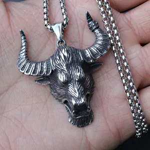 Vintage bull head pendant necklace in stainless steel with a square box chain on palm