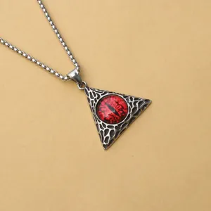 Détail d'un collier punk avec pendentif triangle orné d'un œil du diable rouge intense