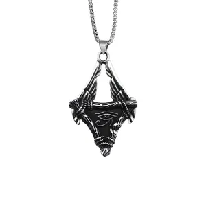 Detail of Eye of Horus pendant with vintage wings and aged steel texture on box chain