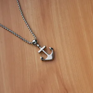 Detailed shot of a nautical anchor pendant with a skull accent on a square pearl chain
