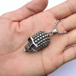Vue détaillée d'un pendentif crâne argenté vintage avec rivets sur la paume de main