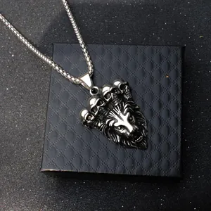 Colgante cabeza de león plateado con calaveras y cadena box en caja de joyas negra