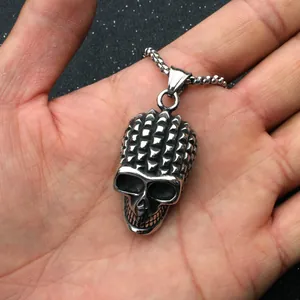 Vue rapprochée du pendentif tête de mort rétro avec texture rivetée dans la main