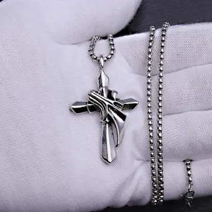 Macro shot of silver vintage stainless steel cross pendant with intricate flame detailing