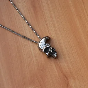 Collana con ciondolo a teschio punk con catena in acciaio su superficie in legno