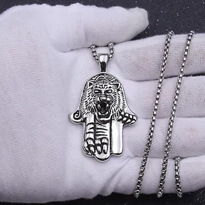 Macro detail of vintage tiger head Hamsa pendant on a steel box chain necklace