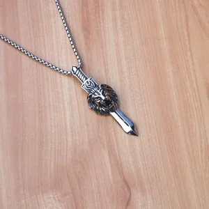 Detalle del colgante de cabeza de león y espada punk en acero plateado envejecido