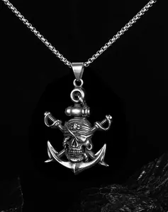 Détail du pendentif crâne de pirate argenté avec ancre et épées sur roche noire
