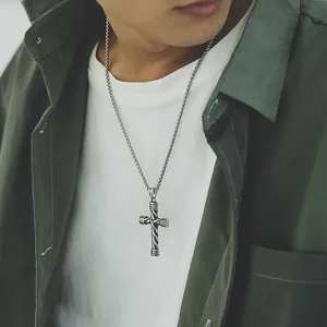 Retro stainless steel cross pendant necklace with twisted texture on a male model