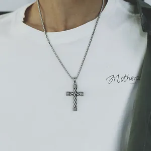 Close-up of vintage textured silver cross pendant on a sturdy box chain for men