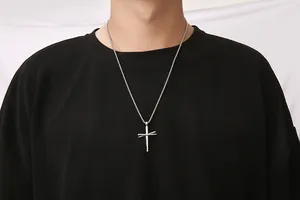 Zilveren kruishanger in honkbalknuppelontwerp op model met zwarte hoodie en ketting
