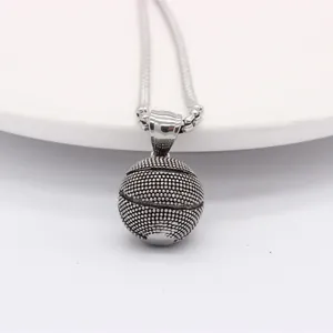 Macro view of retro silver basketball pendant with detailed grip texture on snake chain