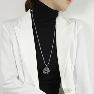 Detail van vintage zonnehanger op een mannelijk model met zwarte coltrui en een blazer