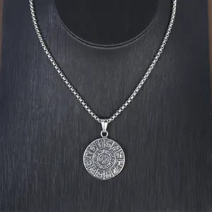 Detalle de un colgante de medallón del zodiaco plateado vintage con símbolos de astrología