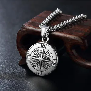 Collier avec pendentif boussole vintage en argent vieilli sur un fond sombre