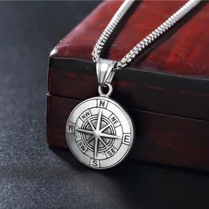 Gros plan détaillé d'un pendentif boussole viking sur une boîte à bijoux en bois vintage