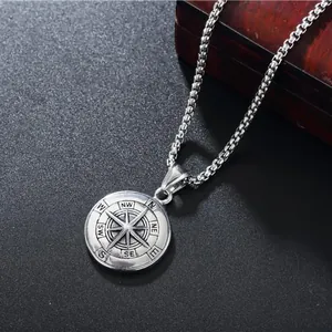 Détail d'un pendentif boussole vintage en acier inoxydable avec points cardinaux