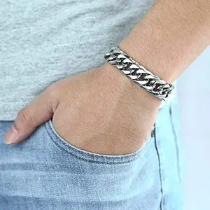 Detail of a 12mm silver stainless steel Cuban link bracelet worn by a male model