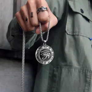 Macro detail of Eye of Horus pendant with hieroglyphs and vintage steel box chain