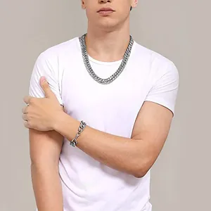 Silver stainless steel Cuban chain necklace and bracelet set shown on a male model