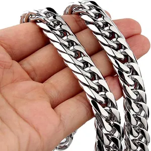 Polished silver stainless steel Cuban link chain necklace held by hand on white background