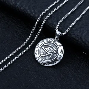 Macro shot of silver Eye of Horus pendant on square box chain over black leather background