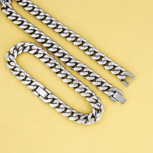 Close-up of polished stainless steel Cuban link chains with rectangular folding clasps