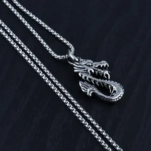Titanium steel dragon pendant necklace with intricate scales on a dark wood background