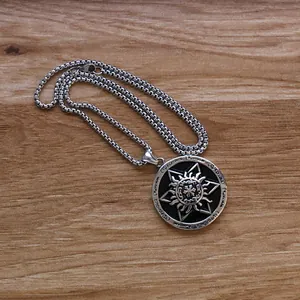 Macro shot of silver hexagram sun pendant with vintage engraving on wooden background