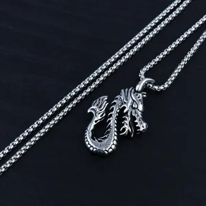Detailed close-up of a Gothic dragon pendant with a thick box chain on a dark background
