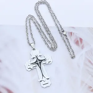 Detalle del colgante de cruz de tres capas plateado con esmalte negro y cadena fina