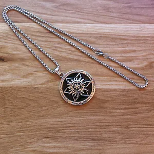 Detail view of round hexagram sun pendant with runic engravings and silver box chain