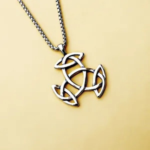 Polished stainless steel Celtic knot pendant necklace with silver link chain on yellow surface