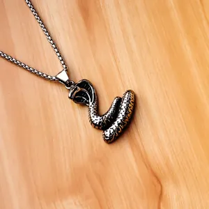Detailed view of silver cobra pendant with scale texture and steel box chain