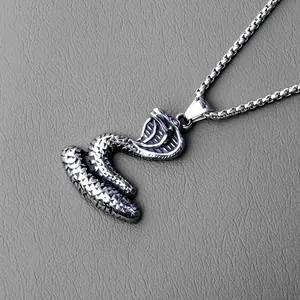 Detailed close-up of a cobra snake pendant with realistic scale textures on a box chain