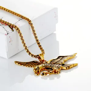 Macro view of golden eagle pendant necklace with detailed feathers on a box chain