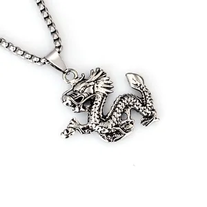 Dettaglio ravvicinato di un ciondolo a forma di drago in argento con catena a maglie box